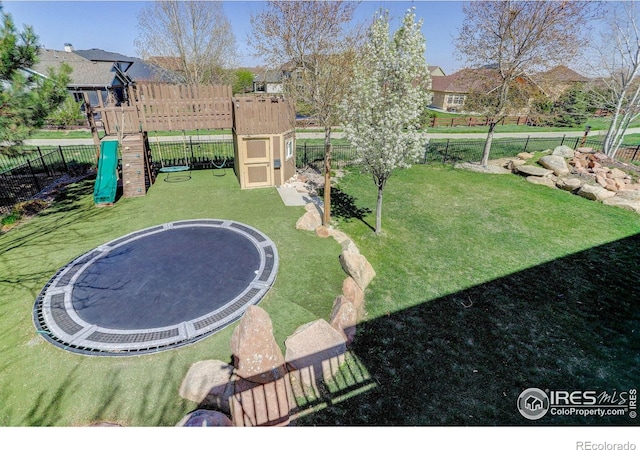 view of yard featuring a fenced backyard, a trampoline, and a playground