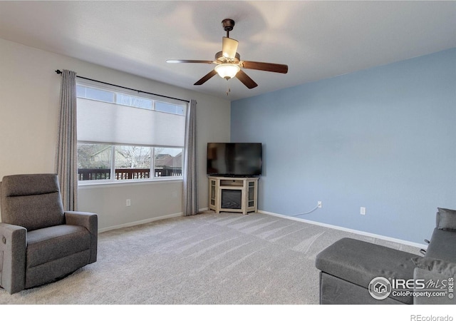 carpeted living room with baseboards and ceiling fan