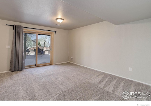 empty room with carpet flooring, baseboards, and visible vents