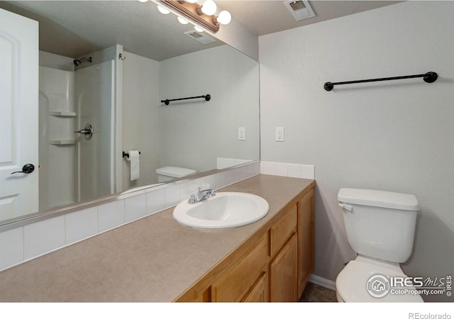full bath featuring visible vents, toilet, vanity, and walk in shower
