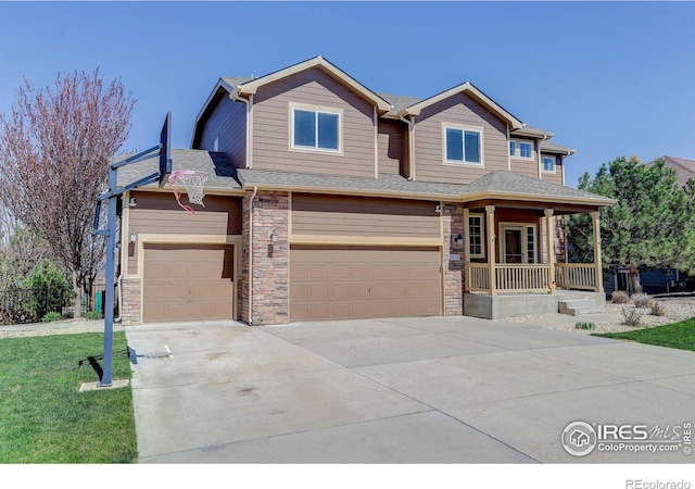 craftsman house featuring a porch, stone siding, a front lawn, an attached garage, and concrete driveway
