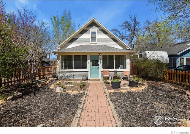 bungalow-style home with fence and a sunroom