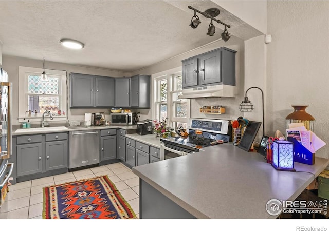 kitchen featuring a sink, appliances with stainless steel finishes, under cabinet range hood, gray cabinetry, and light tile patterned flooring