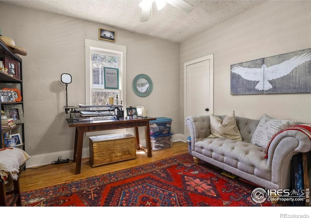 home office featuring a textured ceiling, wood finished floors, and ceiling fan