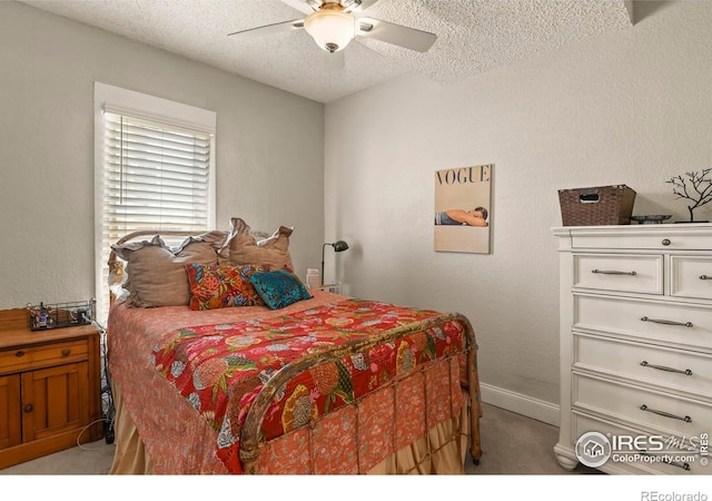 bedroom with baseboards, a ceiling fan, light carpet, and a textured ceiling