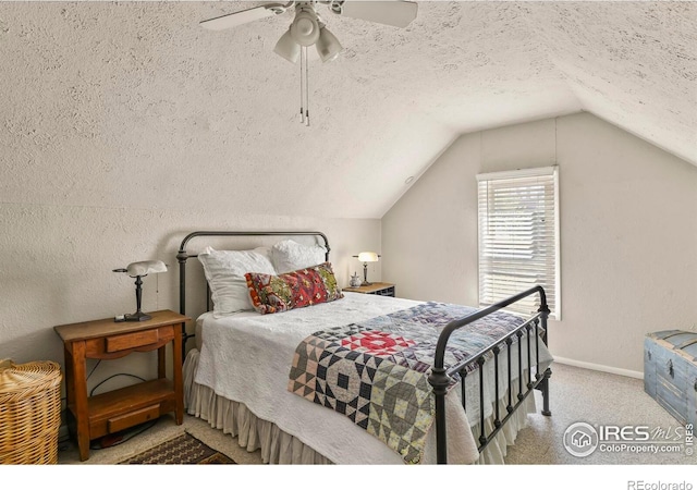 carpeted bedroom with baseboards, a textured ceiling, vaulted ceiling, and ceiling fan