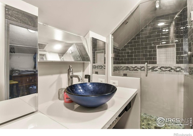 bathroom with vanity, vaulted ceiling, and a stall shower