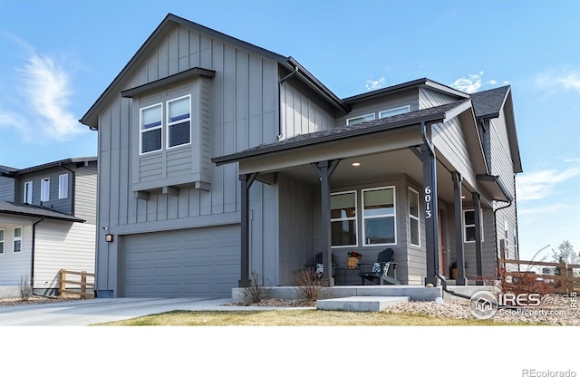 view of front of house with board and batten siding, an attached garage, driveway, and a porch