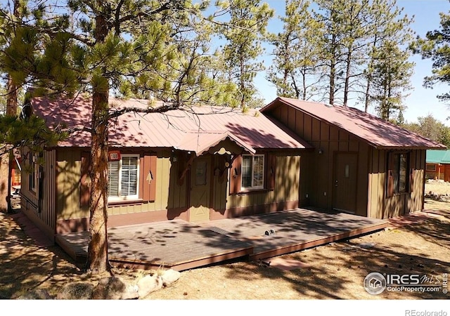 view of front of property with metal roof, board and batten siding, and a wooden deck