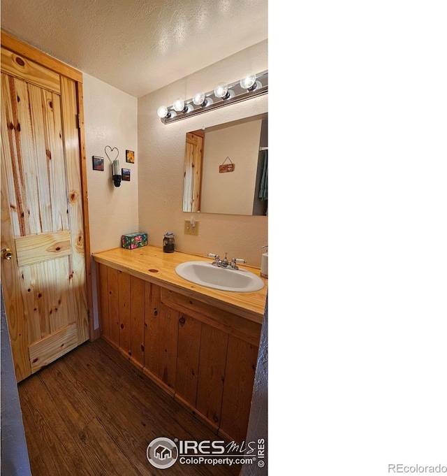 bathroom featuring vanity, a textured ceiling, and wood finished floors