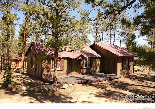 rustic home featuring board and batten siding and a wooden deck