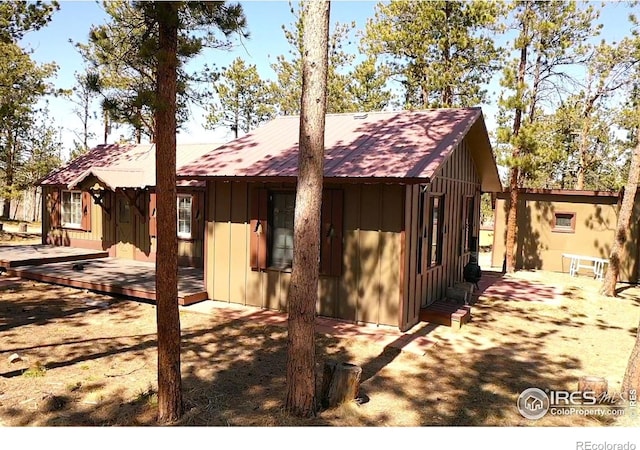 view of property exterior with board and batten siding and a wooden deck