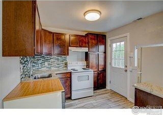 618 19th Ave, Greeley, CO 80631 - kitchen with backsplash, a sink, light countertops, white electric range oven, and extractor fan