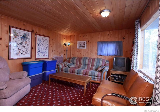 carpeted living room with wooden ceiling and wood walls