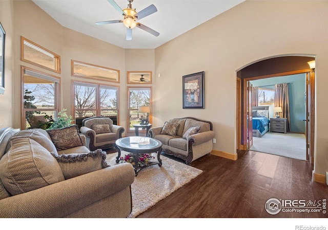 432 Valley View Rd, Loveland, CO 80537 - living area featuring a ceiling fan, arched walkways, baseboards, a high ceiling, and dark wood-style flooring