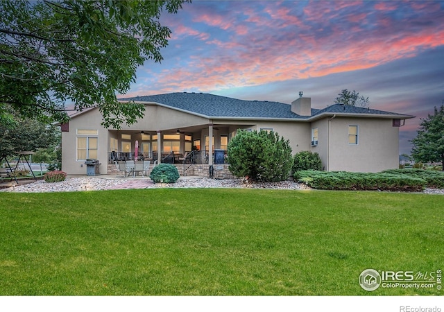 432 Valley View Rd, Loveland, CO 80537 - back of house at dusk featuring a patio, a ceiling fan, a yard, and stucco siding