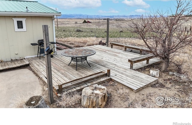 wooden terrace featuring a rural view and a mountain view