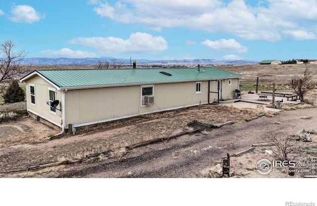 back of house with metal roof, cooling unit, and a mountain view