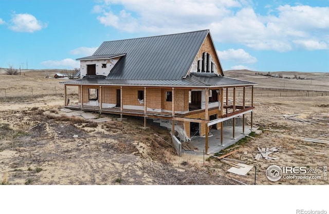 rear view of property featuring metal roof and a patio area