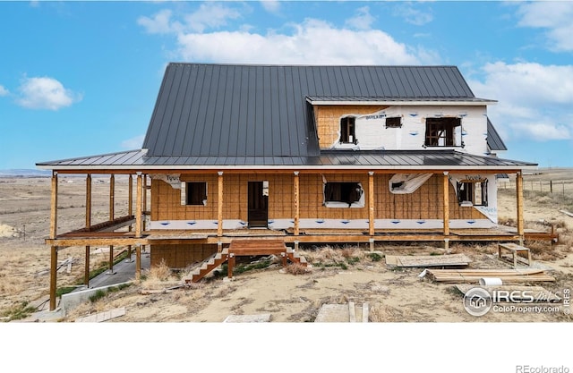 rear view of property with a porch, a standing seam roof, and metal roof