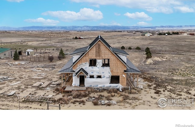 view of front of home with a rural view, a mountain view, and view of desert