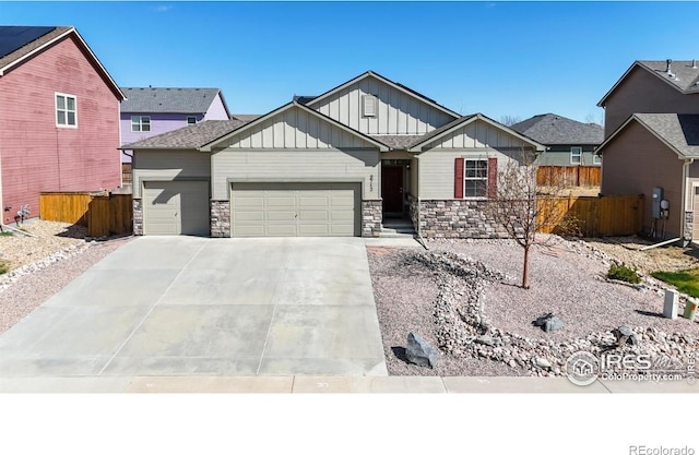 3712 Daylily St, Wellington, CO 80549 - view of front of home with board and batten siding, fence, stone siding, and a garage