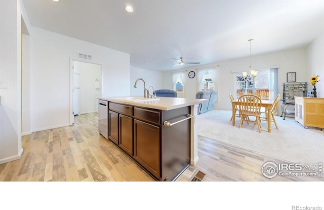 3712 Daylily St, Wellington, CO 80549 - kitchen featuring light countertops, light wood finished floors, dishwasher, ceiling fan with notable chandelier, and a sink