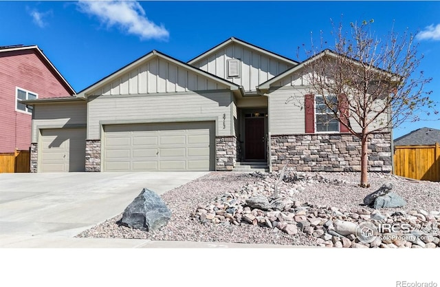 3712 Daylily St, Wellington, CO 80549 - craftsman house featuring an attached garage, board and batten siding, fence, and stone siding