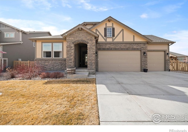 view of front of home featuring concrete driveway, stucco siding, stone siding, a front yard, and a garage