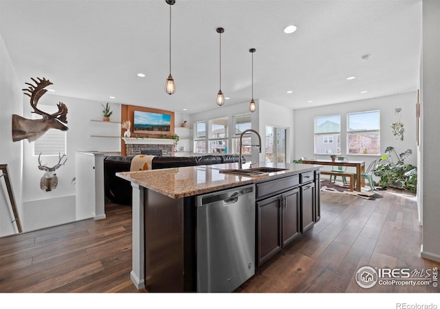 kitchen featuring light stone counters, recessed lighting, dark wood-type flooring, stainless steel dishwasher, and a sink