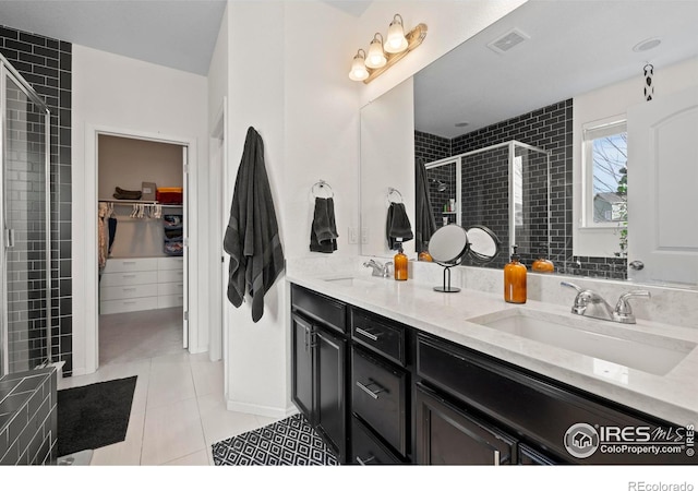 full bath with a shower stall, double vanity, visible vents, and a sink