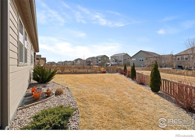 view of yard with a fenced backyard and a residential view