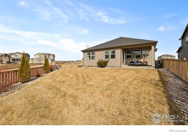 rear view of property with a patio area, a fenced backyard, and a lawn