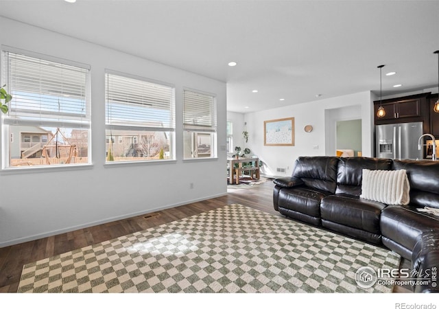 living area with wood finished floors, baseboards, visible vents, and recessed lighting