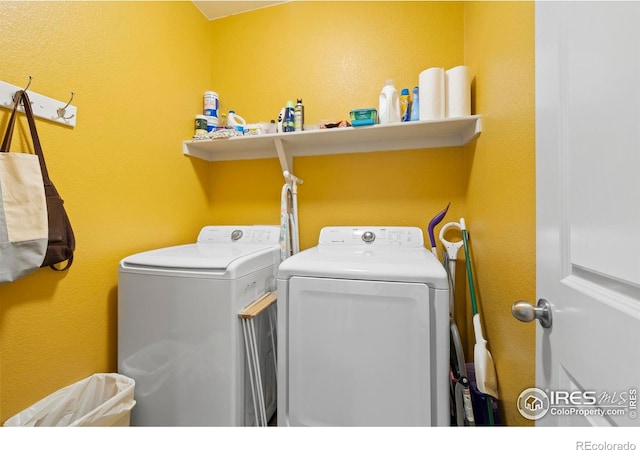 laundry area featuring laundry area, washing machine and clothes dryer, and a textured wall