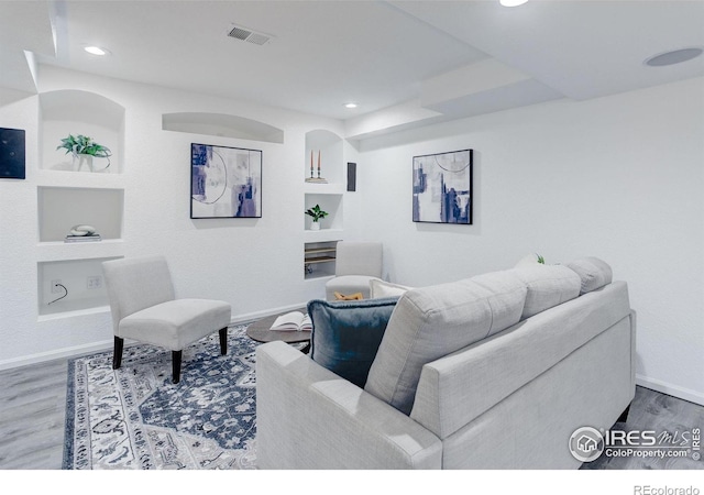 living area with wood finished floors, baseboards, visible vents, and recessed lighting