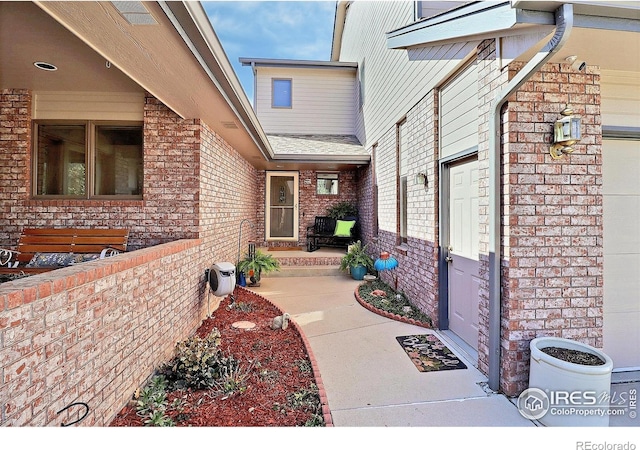 view of exterior entry featuring brick siding