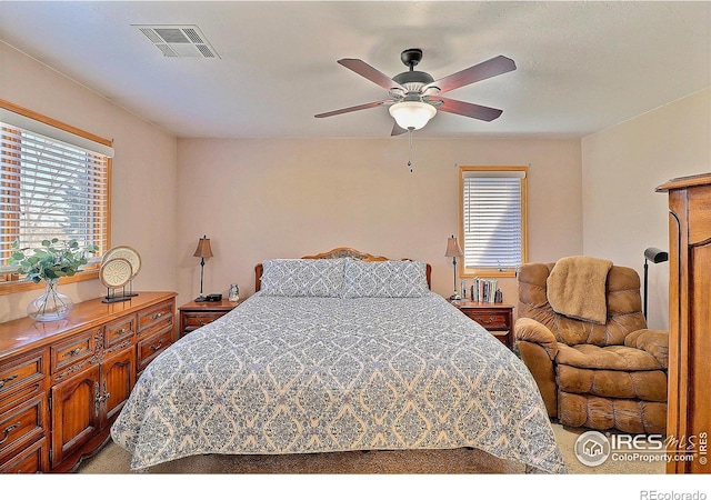 carpeted bedroom with visible vents and a ceiling fan