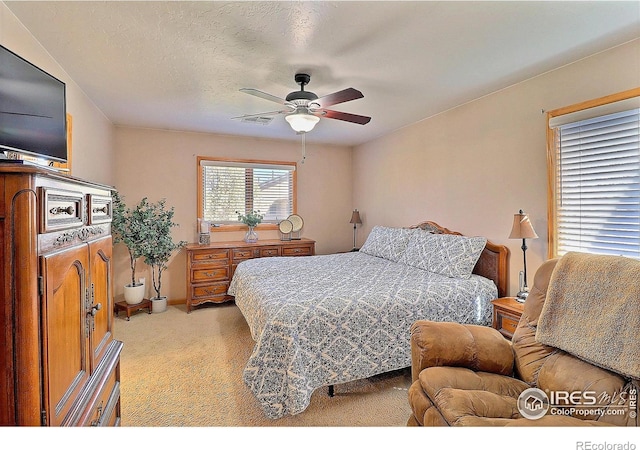 bedroom featuring visible vents, ceiling fan, and light colored carpet