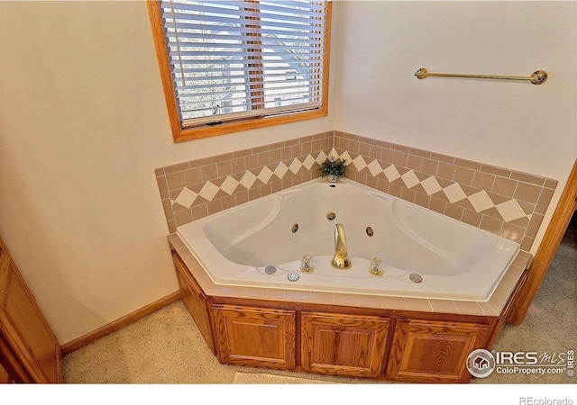 bathroom with a jetted tub and baseboards