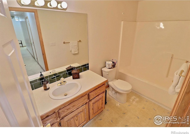 bathroom with toilet, tile patterned floors, vanity, and  shower combination