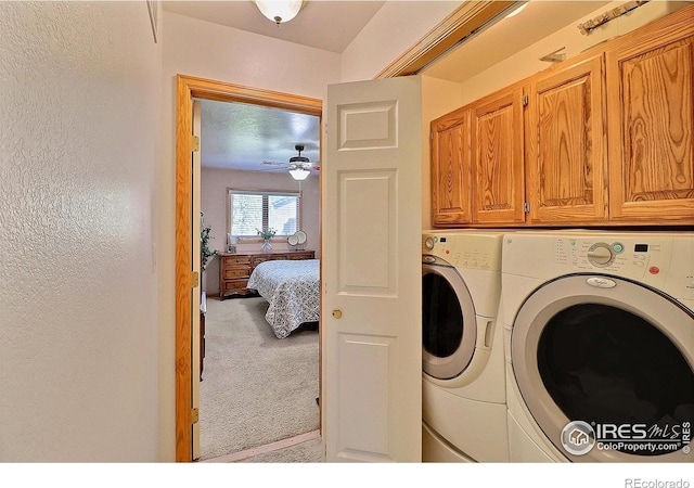 clothes washing area featuring a ceiling fan, separate washer and dryer, carpet, and cabinet space