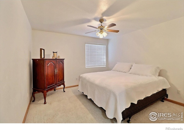 bedroom featuring light carpet, baseboards, and a ceiling fan