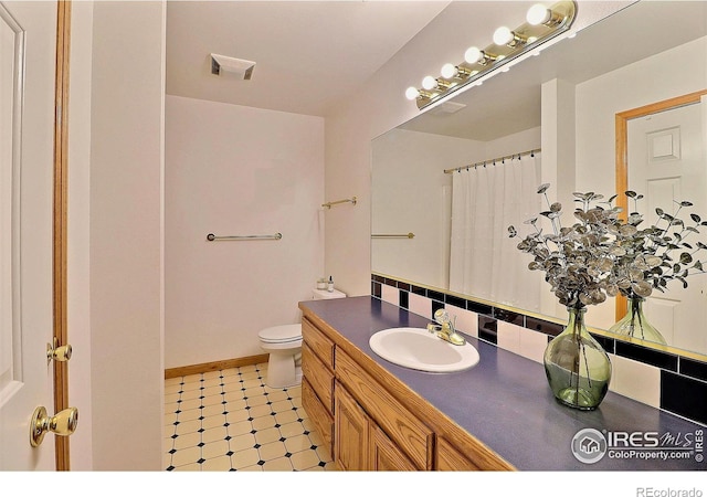bathroom with visible vents, toilet, vanity, tile patterned floors, and decorative backsplash