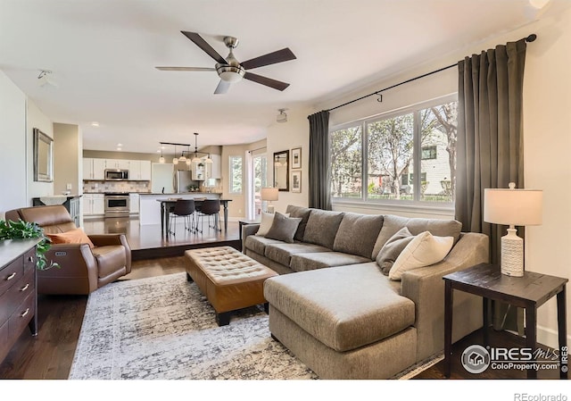 living room with ceiling fan and dark wood-style floors