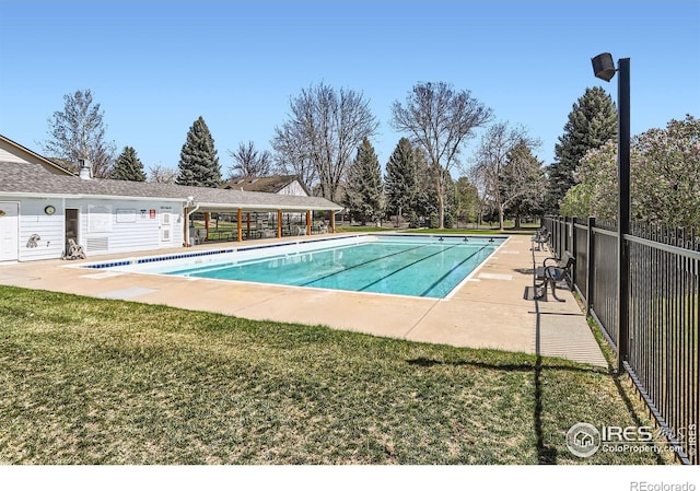 community pool featuring a yard, fence, and a patio