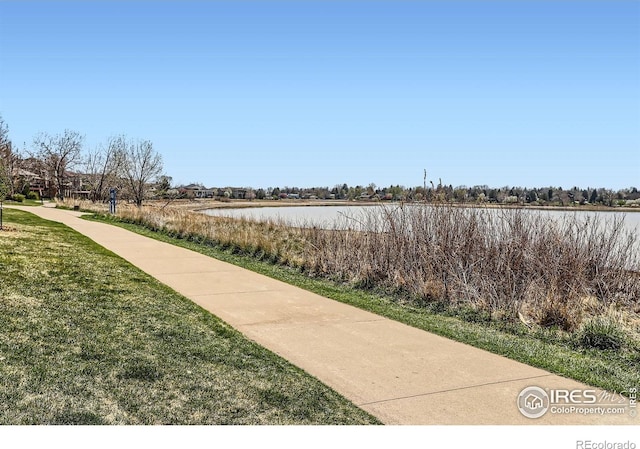 view of community with a water view and a lawn