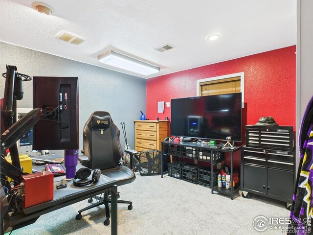 workout area with a textured wall, carpet flooring, visible vents, and a textured ceiling