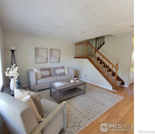 104 Pheasant Run, Louisville, CO 80027 - living room featuring wood finished floors, stairway, and baseboards