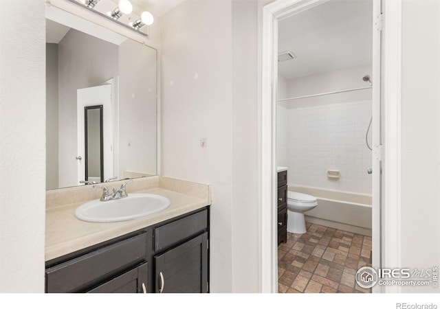 104 Pheasant Run, Louisville, CO 80027 - bathroom featuring vanity, toilet, brick patterned flooring, and tub / shower combination